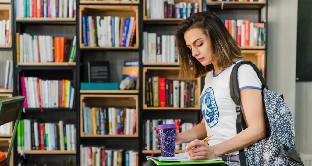 Girl sitting holding notebook on knee writing