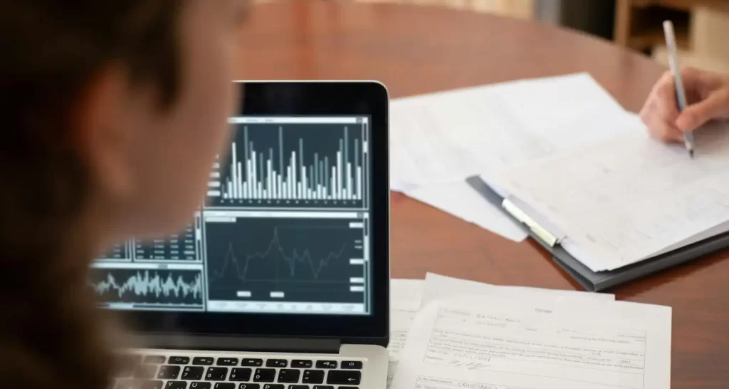 Laptop and Papers of Employees During a Meeting