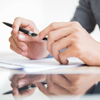 Businessman sitting at table with pen in hands