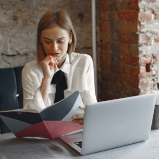 Businesswoman sitting at the table with a laptop