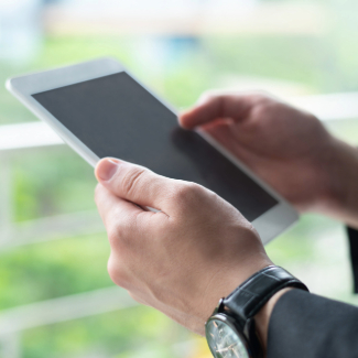Closeup of business person using tablet computer at window