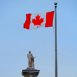 Montreal architecture with statue and canada national flag