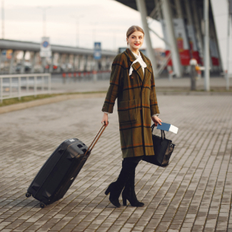 Woman with suitcase standing by the airport