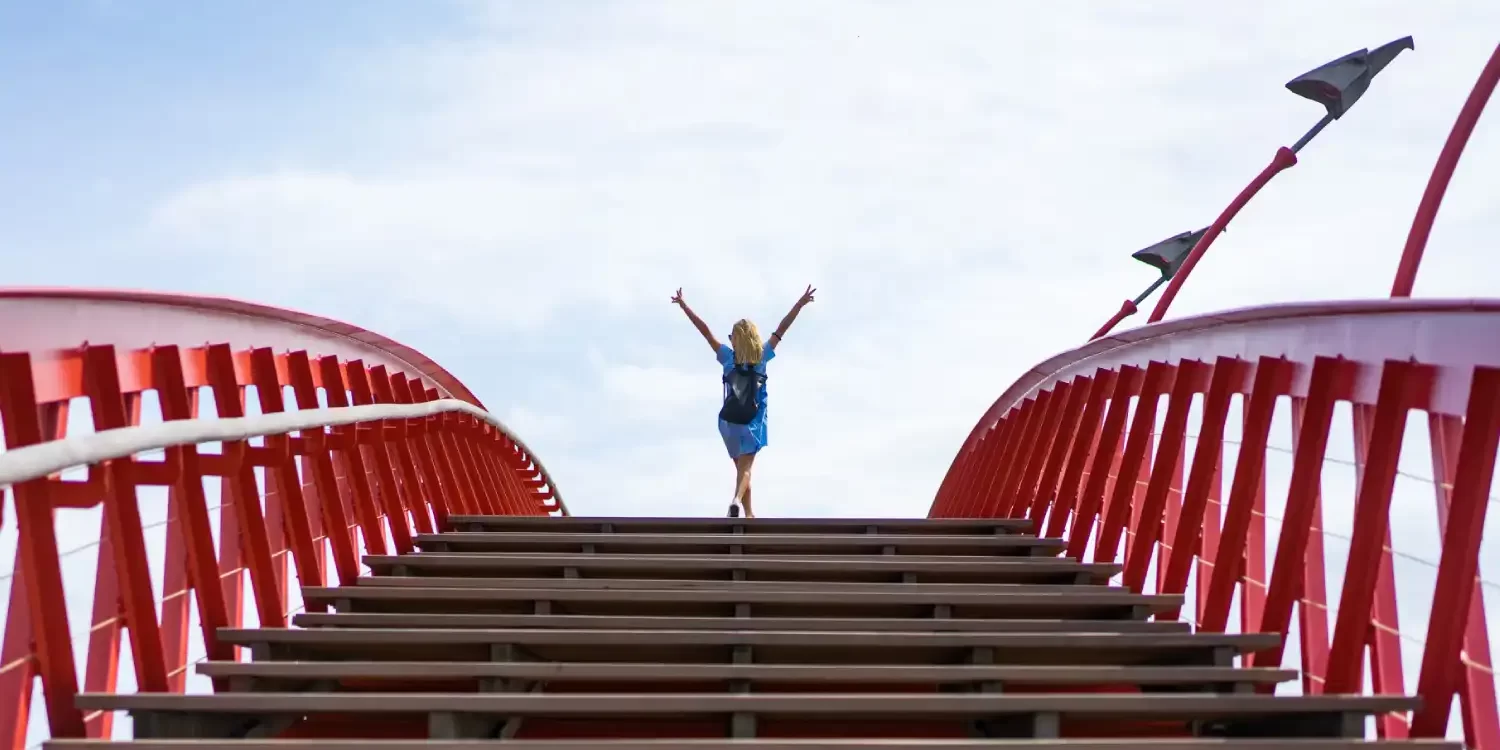 Beautiful girl in a blue dress posing on the bridge