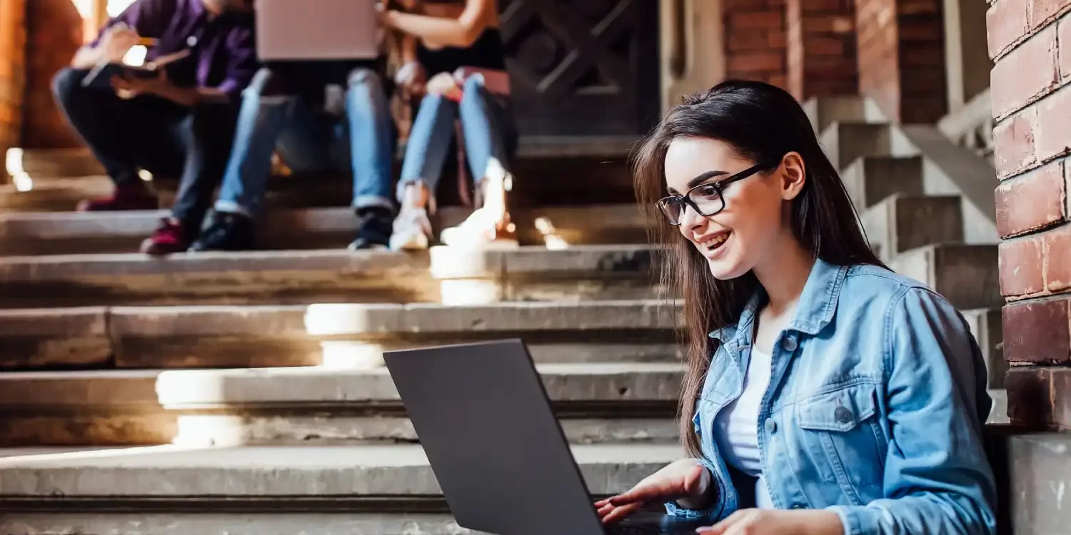 College girl working with laptop after lessons