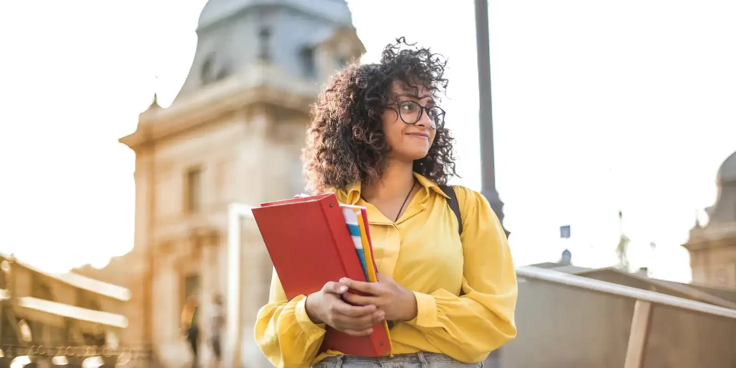 Woman In Yellow Jacket Holding Books