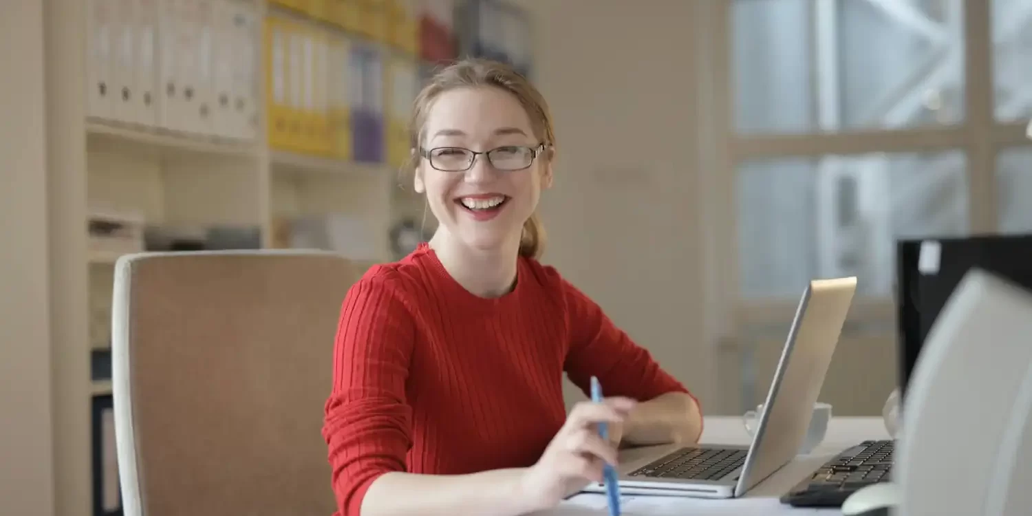 Woman in Red Sweater Leaning on White Table